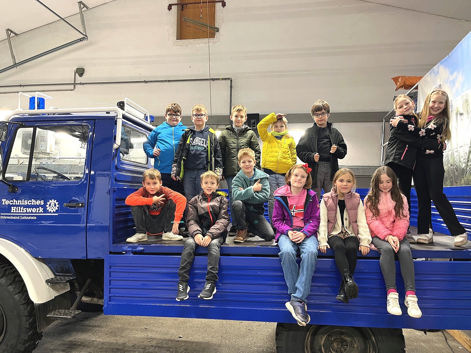 Kommunionkinder auf der Ladefläche eines THW-LKW