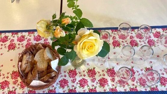 eingedeckter Tisch mit Brot und Rosen
