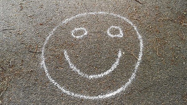 mit Kreide auf den Boden gemalter Smiley