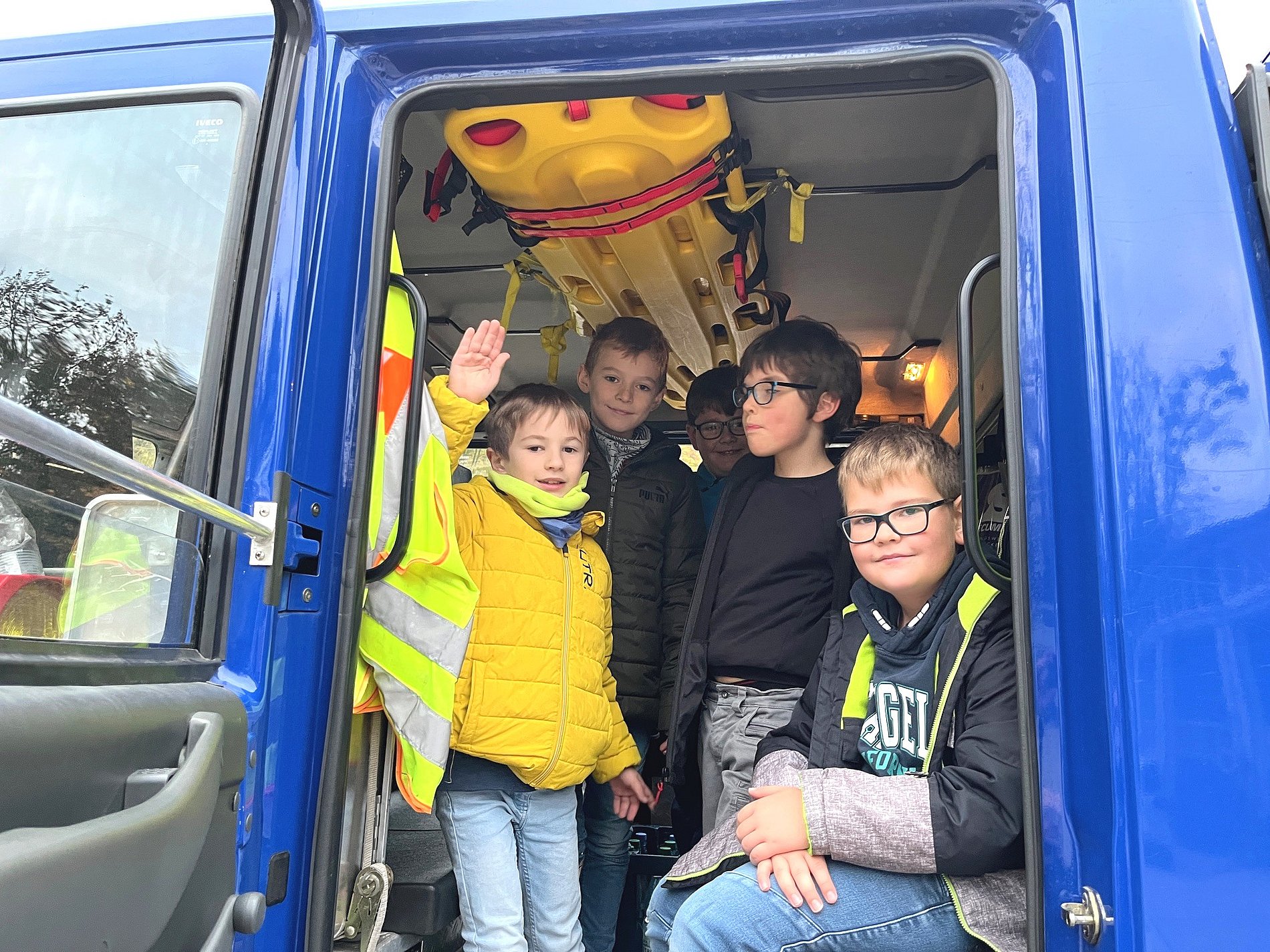 Kommunionkinder sitzen im Führerhaus des THW-LKW