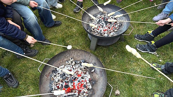 Stockbrot Kommunionkinder rösten Stockbrot über zwei Feuerschalen