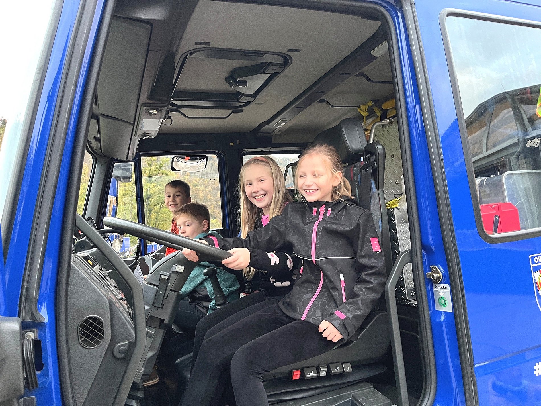 Kommunionkinder im Führerhaus eines THW-Lastkraftwagens