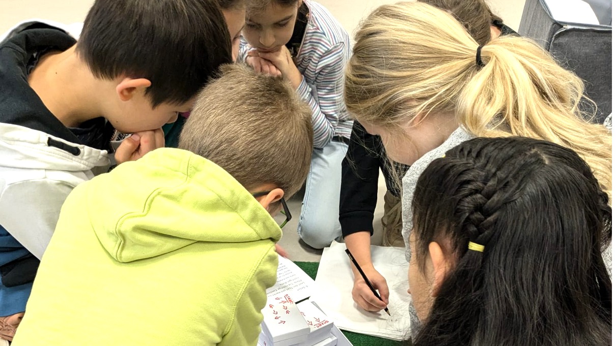 Kommunionkinder stecken die Köpfe zusammen, um ein Rätsel zu lösen