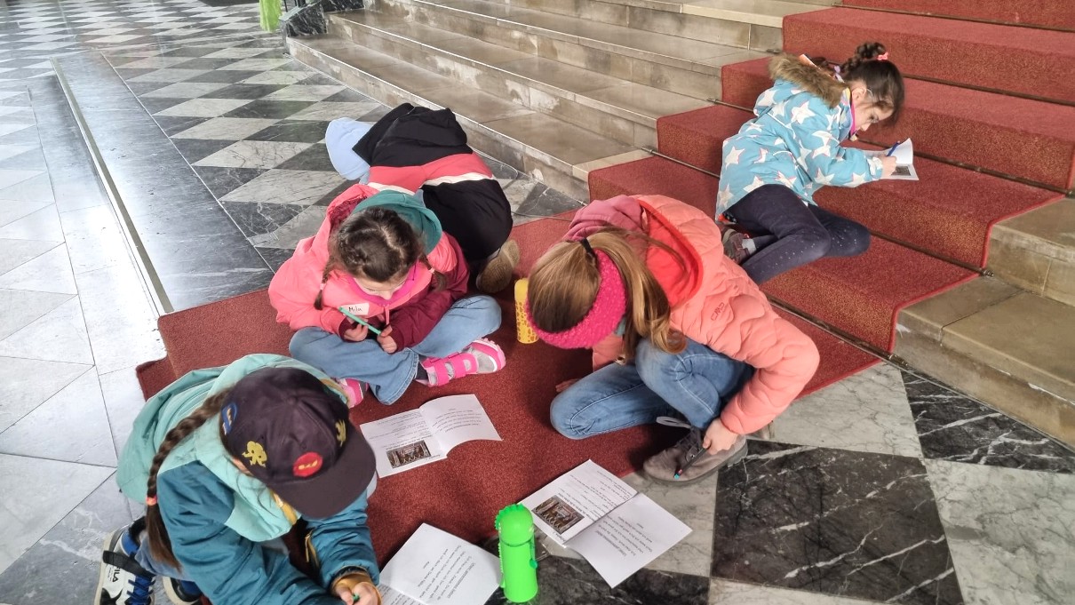 Kommunionkinder schreiben auf den Stufen der Martinskirche 